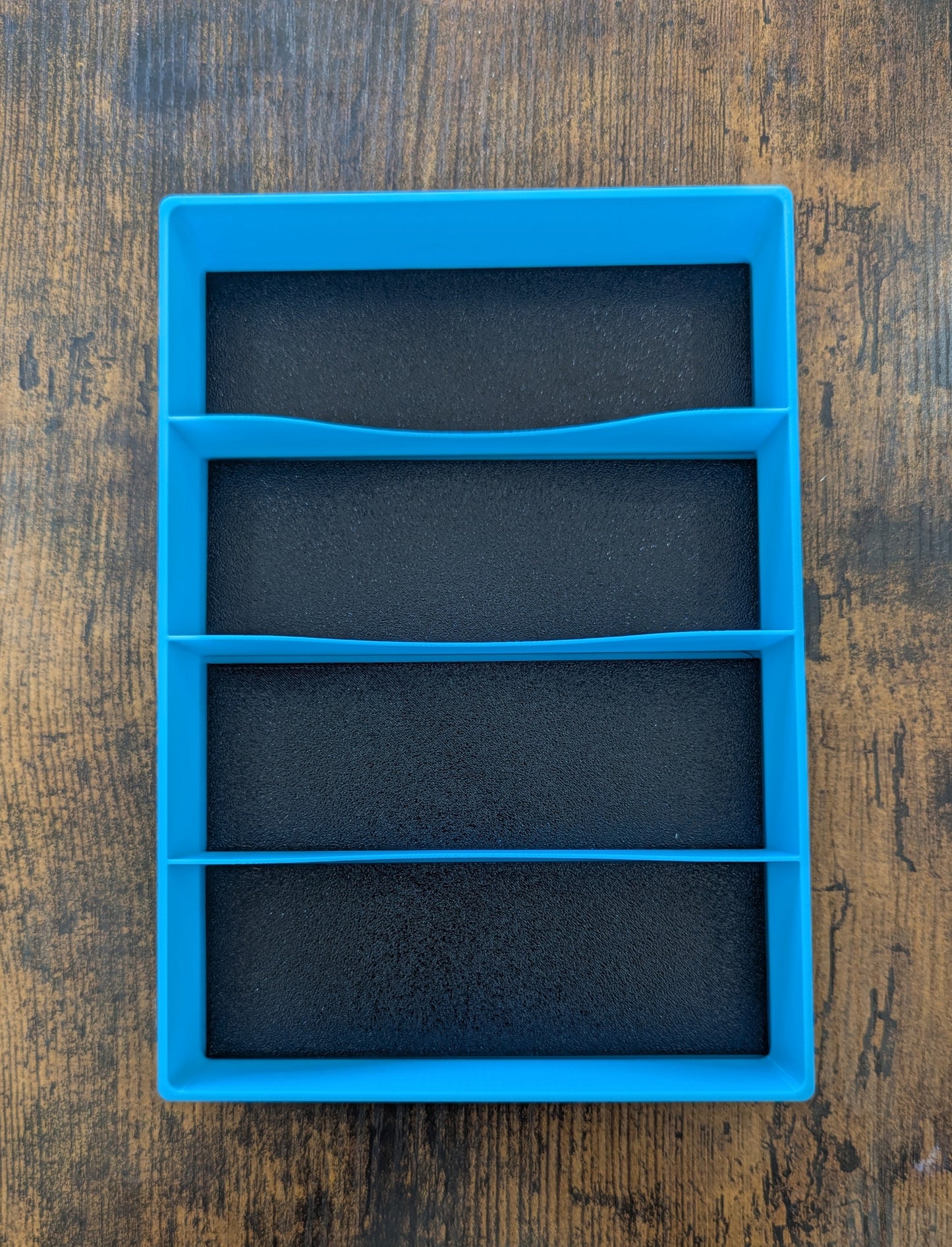 Blue rectangular silicone mold on a wooden surface
